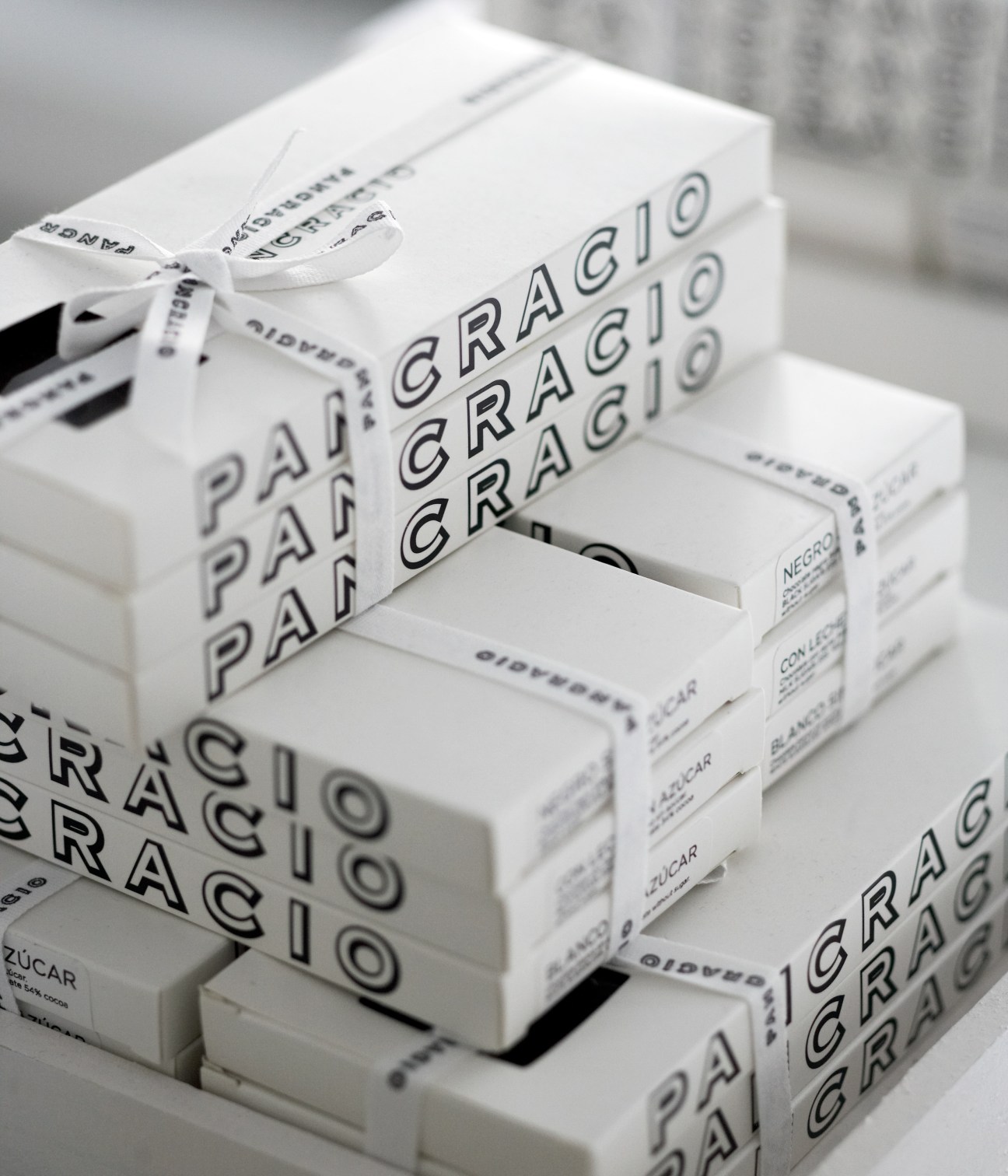 Stacked white boxes of Pancracio gourmet chocolate with ribbon bow