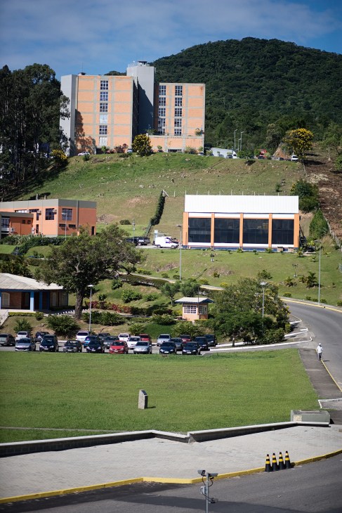 Alfa Technology Park buildings nestled in forested hills with orange and white office structures on green grounds.