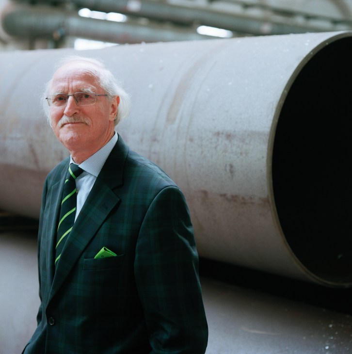 Dietrich Stein stands in front of a large industrial cargo tube in a warehouse facility.