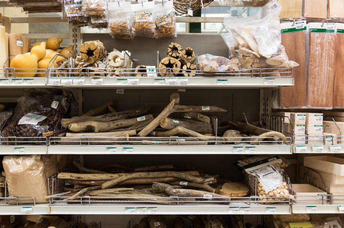 Shelves displaying gourds, driftwood, and wood craft materials at Tokyu Hands wood department.