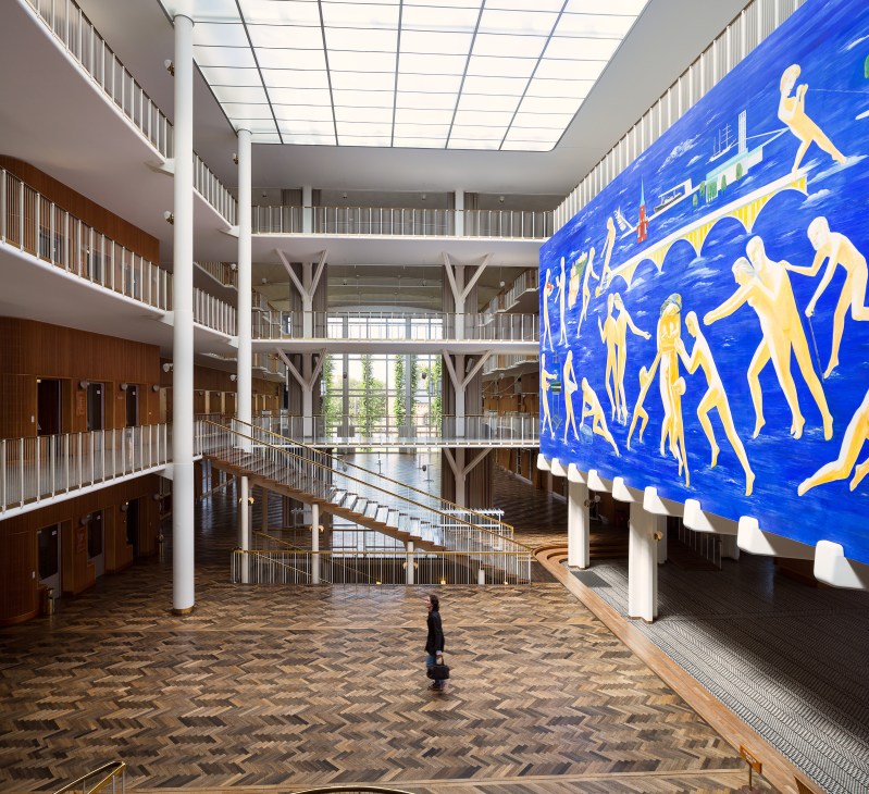 Interior of Aarhus city hall with large blue mural by Thorvald Hagedorn-Olsen featuring yellow figures.