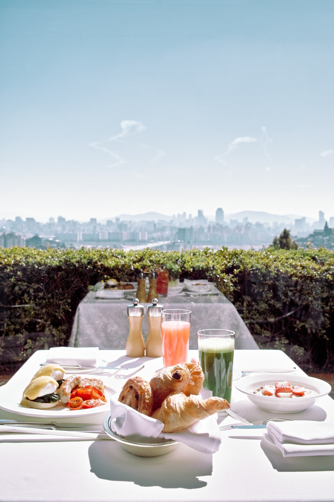 Breakfast spread with pastries and beverages overlooking a city skyline from Grand Hyatt Seoul.