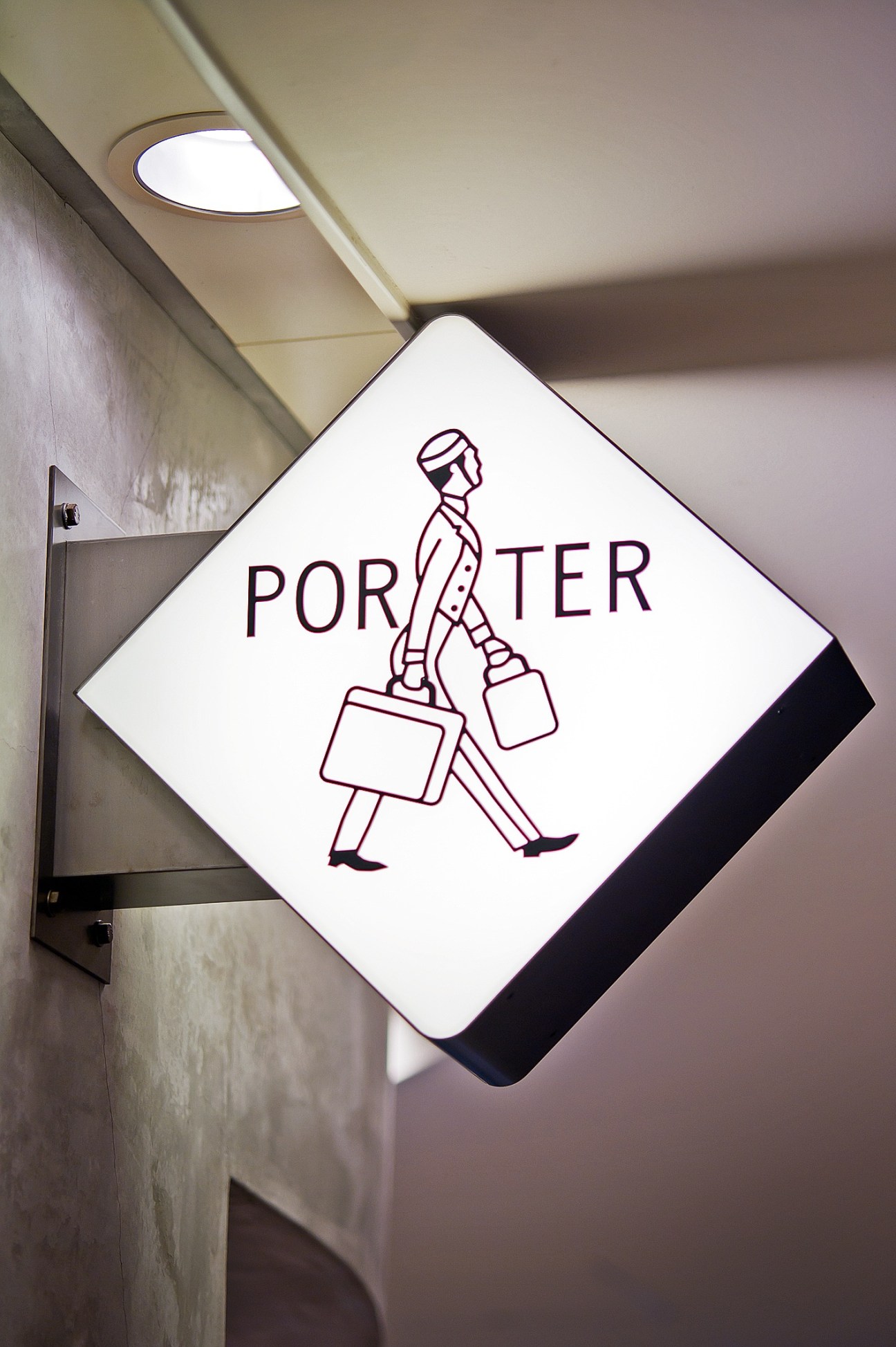 Porter shop signage at Narita airport featuring illustrated figure carrying luggage