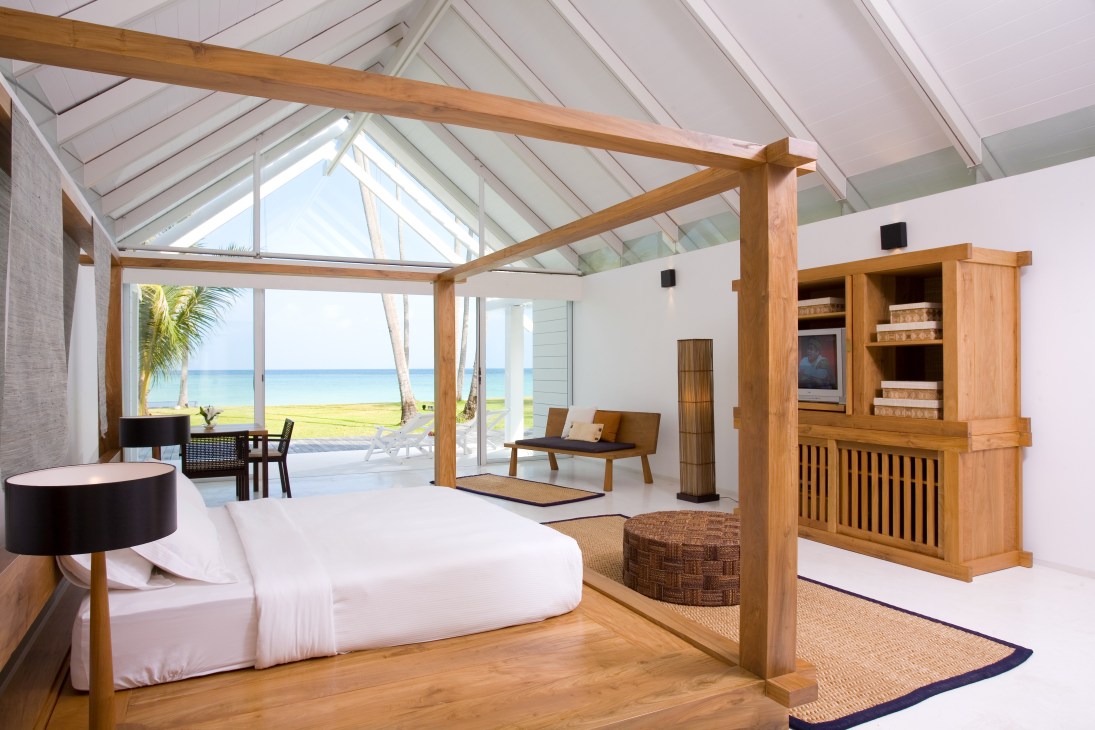 Spacious beachfront villa interior with wooden ceiling beams, white walls, teak furniture and ocean view at YL Residence No 17.