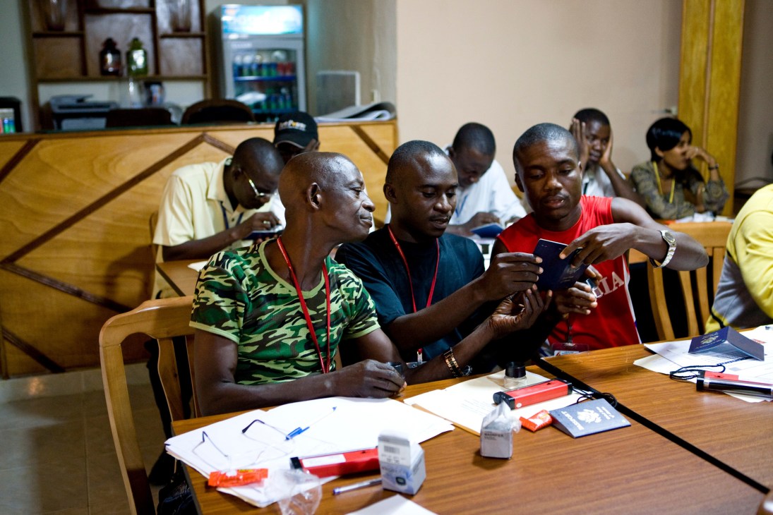 Liberian airport security staff examine passports during a TSA training session on detecting fraudulent documents.