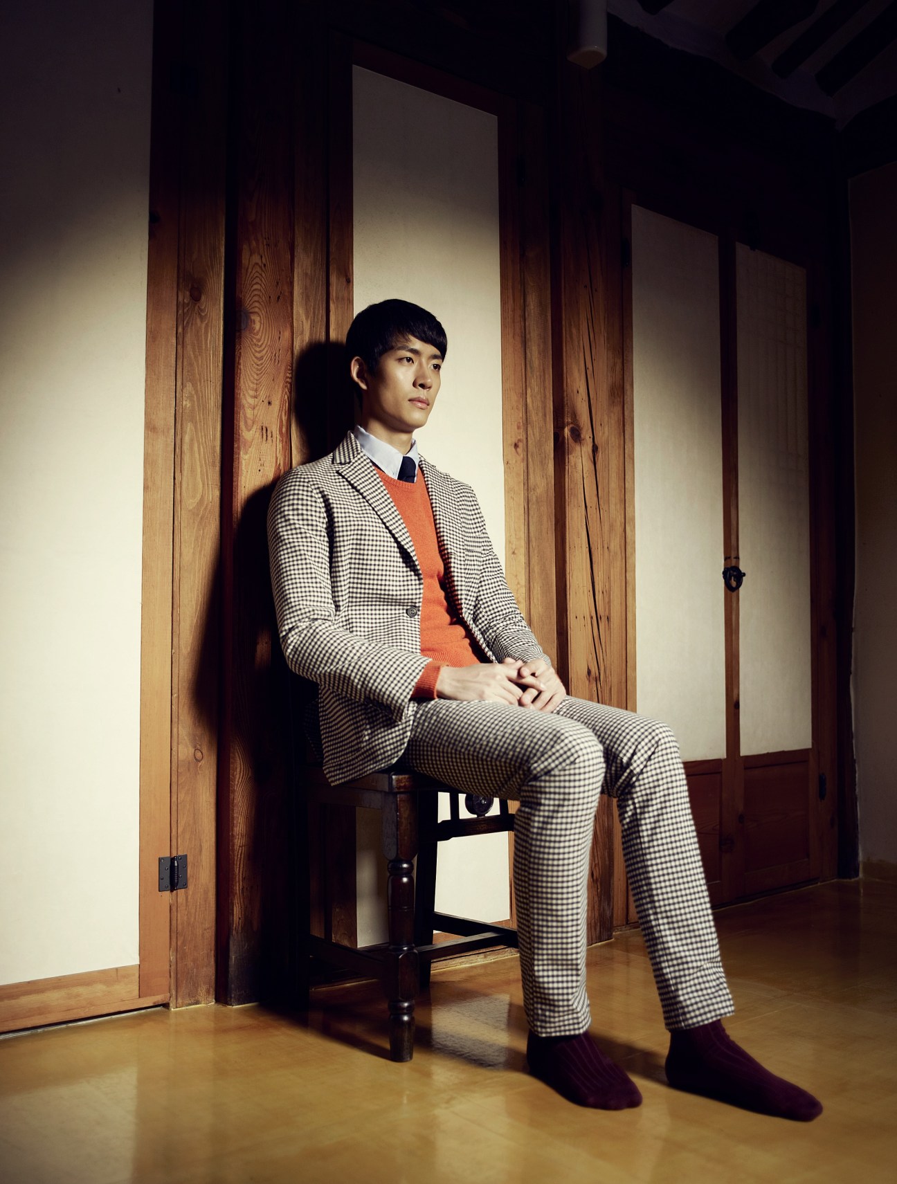Man seated in traditional Korean interior wearing East Habour Surplus jacket and trousers with E. Tautz jumper.