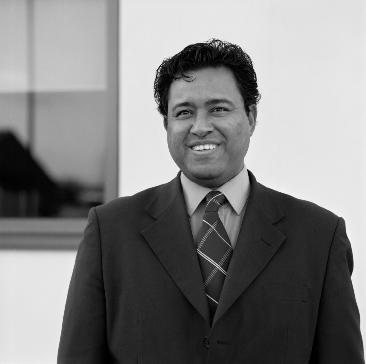 Allen Vincatassin, a Diego Garcian exile, in a black and white portrait wearing a dark suit and patterned tie.