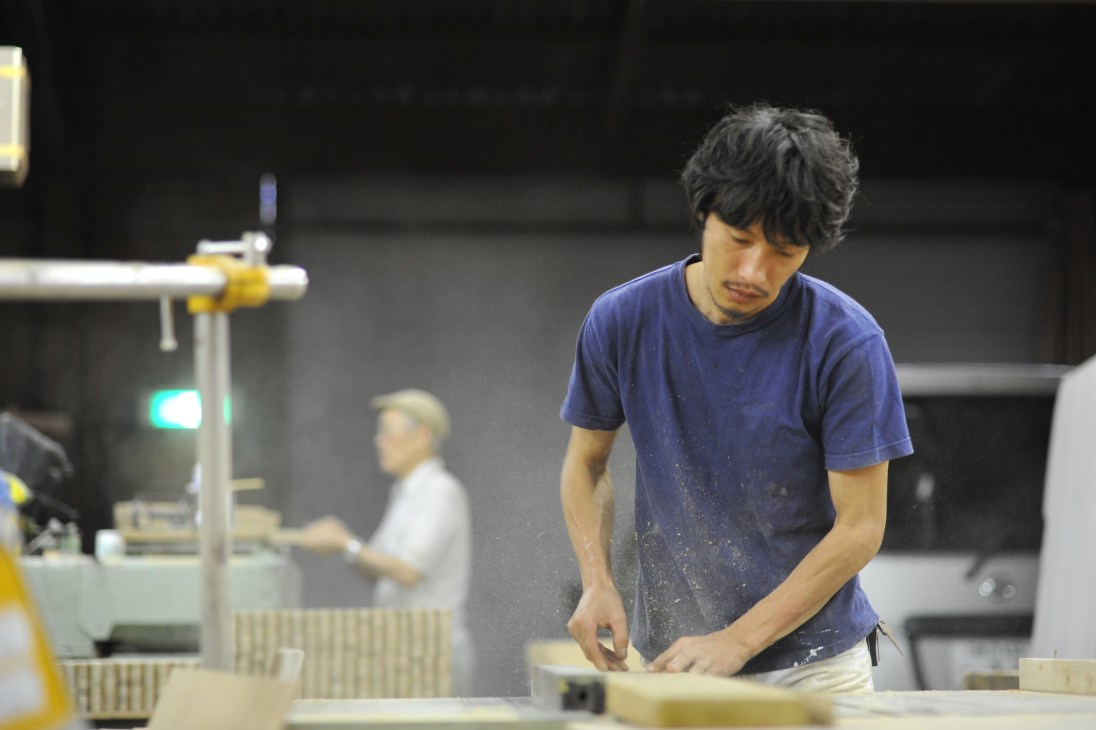 Makoto Nakahara works on a wooden piece in his furniture studio.