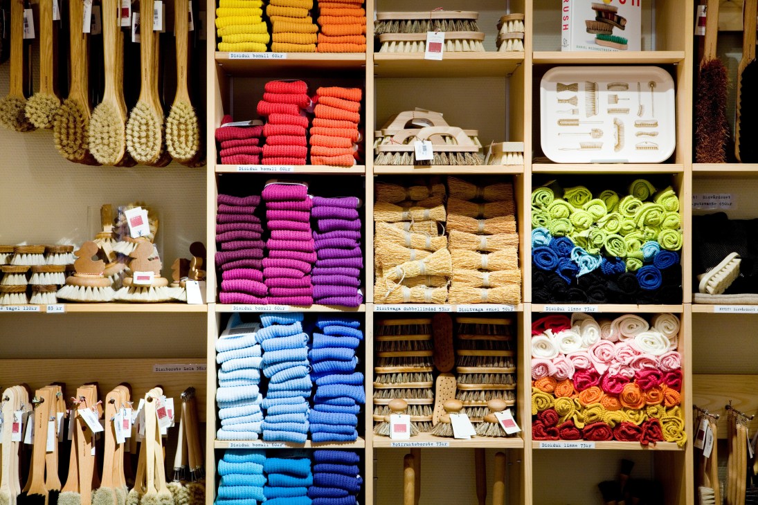Iris Hantverk brushes and materials organized on shelves in the Gamla Stan store, displaying wooden-handled brushes and colorful bristle materials.