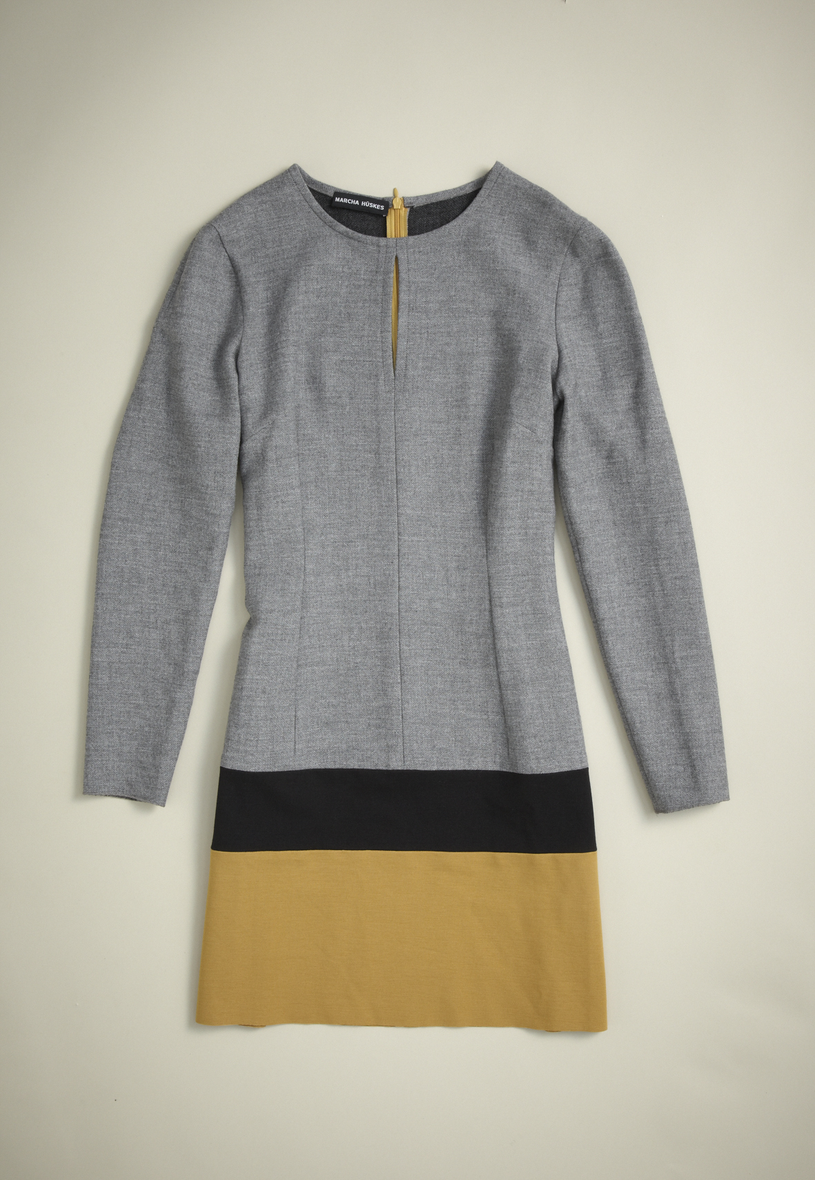 Gray long-sleeve dress with black and mustard-yellow colorblock hem by Marcha Hüskes.
