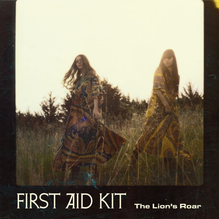 First Aid Kit album cover showing two women in patterned dresses standing in a field.