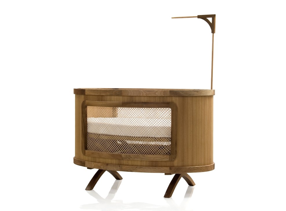 Wooden baby cot with curved sides, mesh panel, and angled legs with overhead canopy arm.