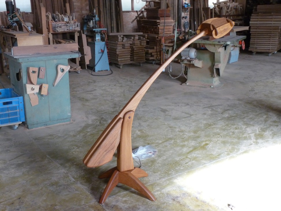 Sculptural wooden furniture by Morito Ebine displayed in a workshop with machinery and materials.