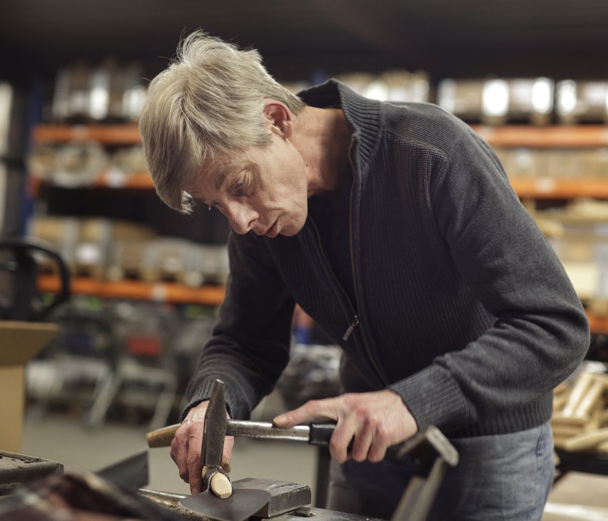 DeWit employee Douwe Douwstra working on a tool at the factory workbench.