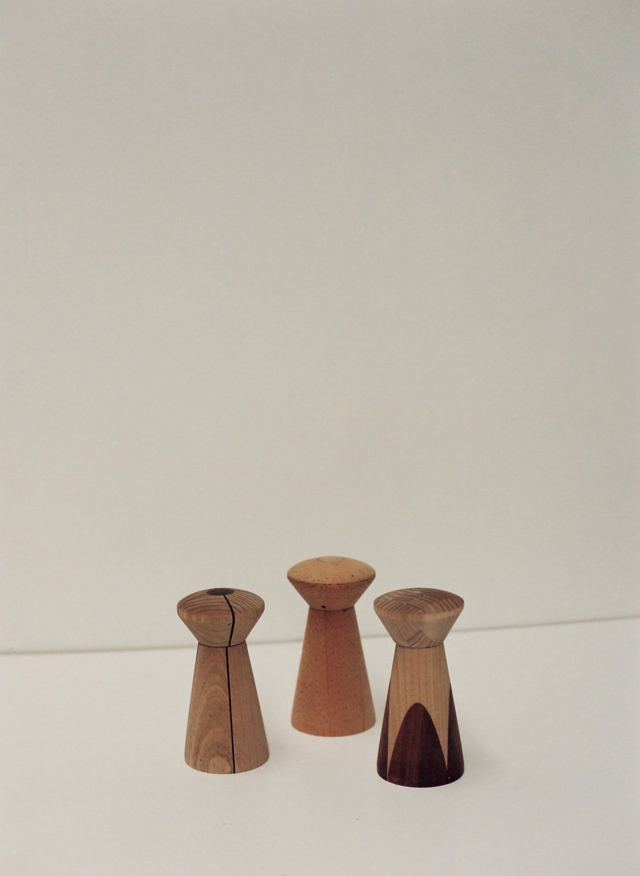 Three wooden salt and pepper shakers with conical shapes by Malcolm Harris.