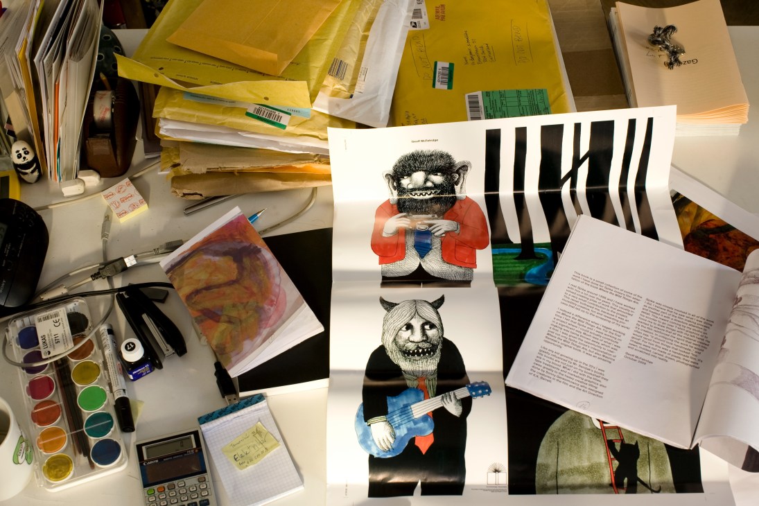 Geoff McFetridge's illustrations of quirky creatures displayed on Benjamin Sommerhalder's desk amid art supplies and publishing materials.