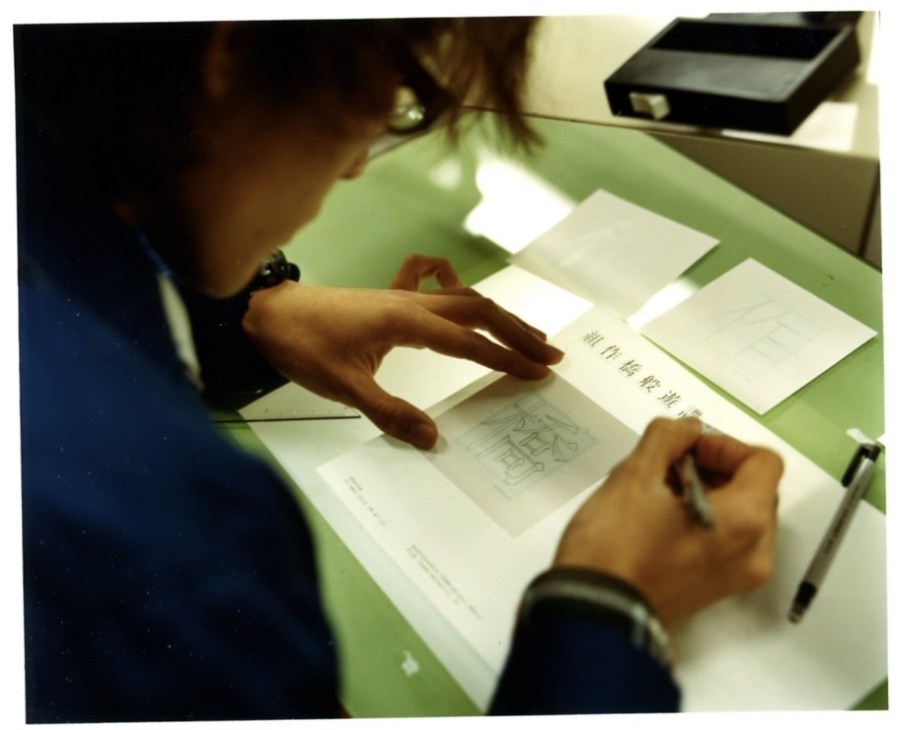 Designer tracing fonts over a light-box at Morisawa font factory.