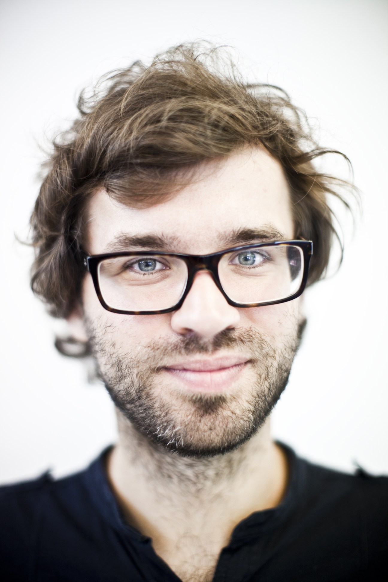 Sebastian Cichocki, curator of Warsaw Under Construction festival, wearing glasses against a white background.