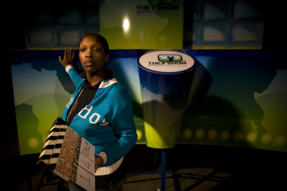 Intern Wangeci Kimani holding a film clapper board on The XYZ Show set in Nairobi.