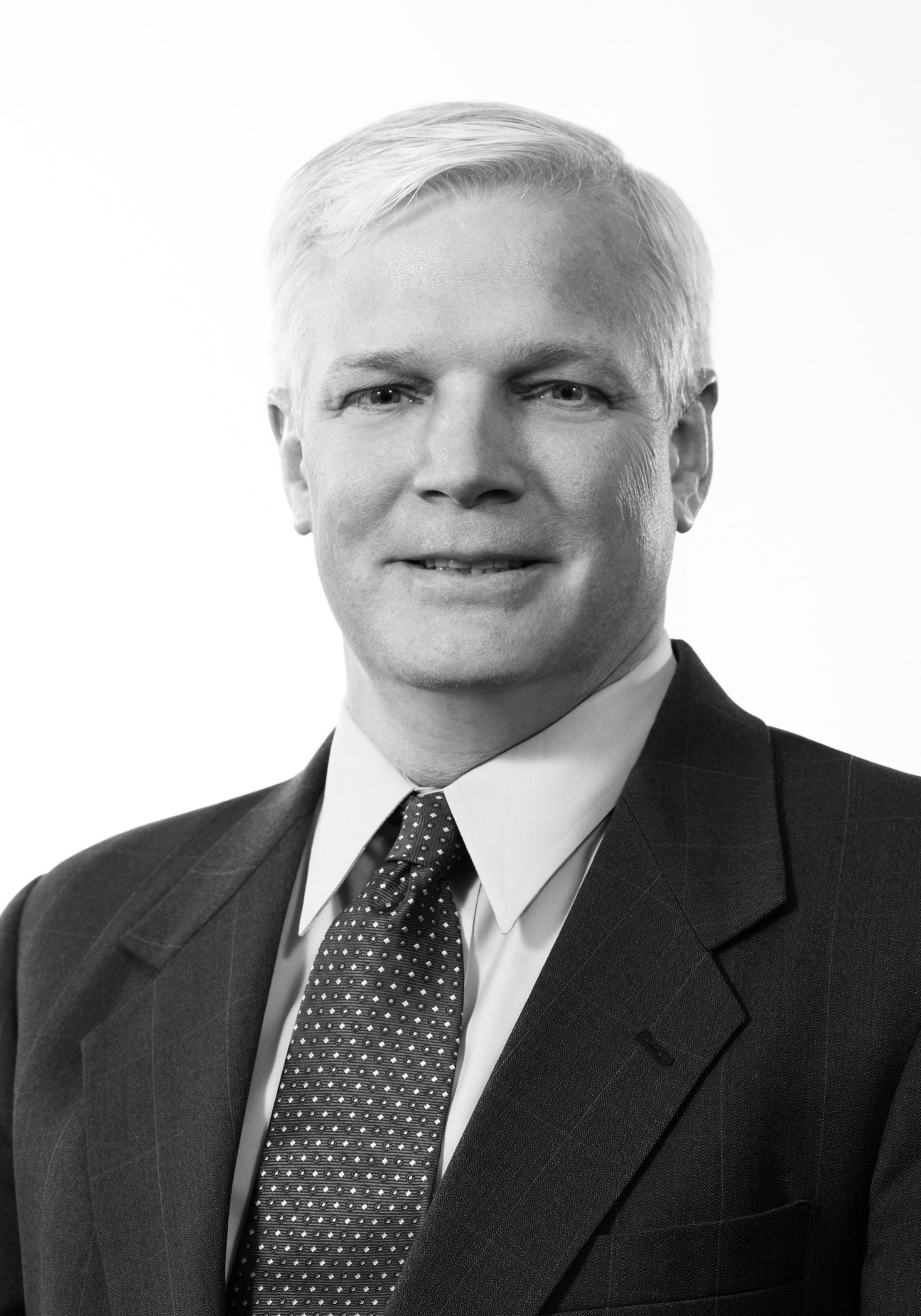 Black and white portrait of Richard Meeusen, CEO of Badger Meter, wearing a dark suit and patterned tie.