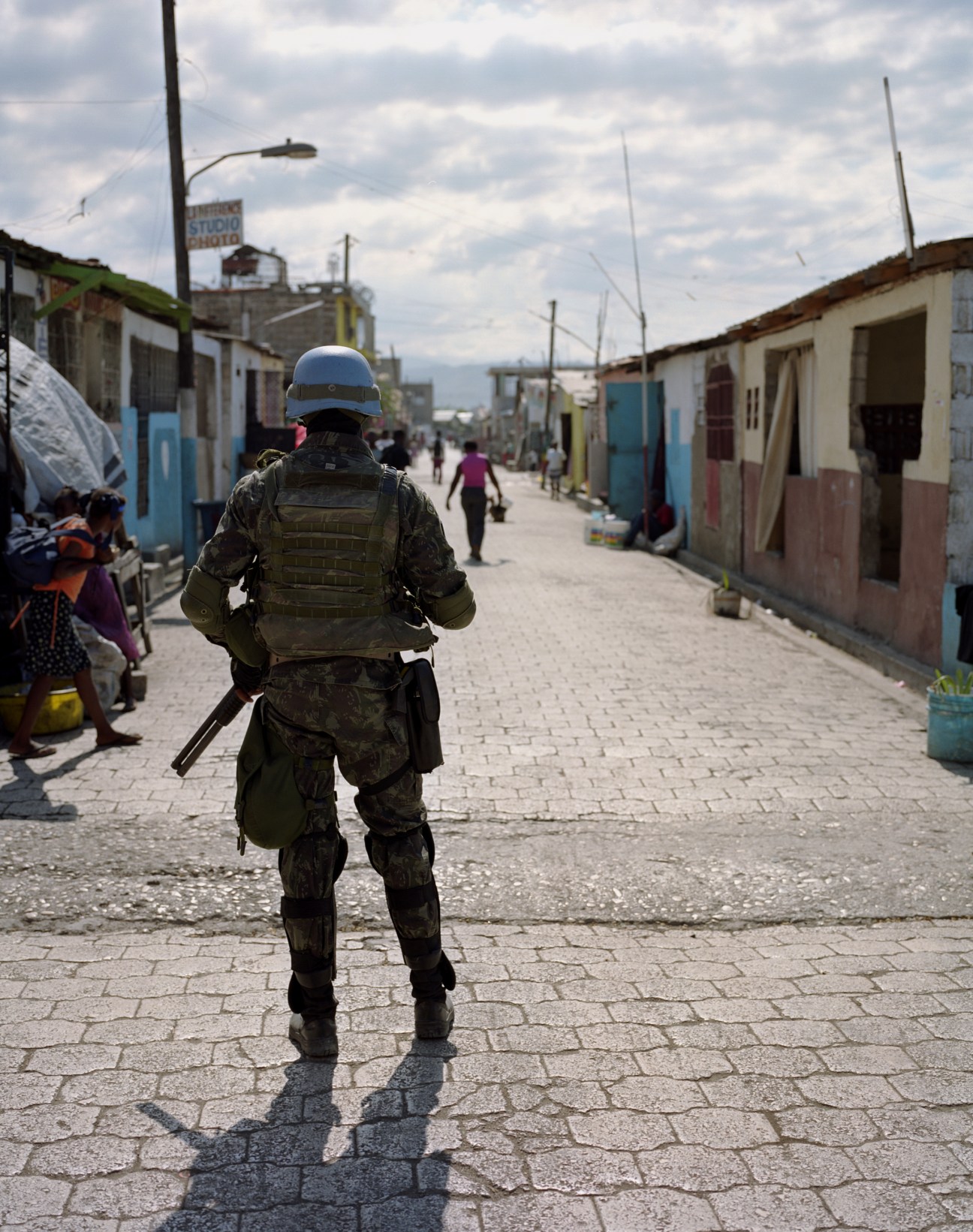 A Brazilian soldier on patrol walks down a street in the Cité Soleil shantytown in Port-au-Prince, Haiti.