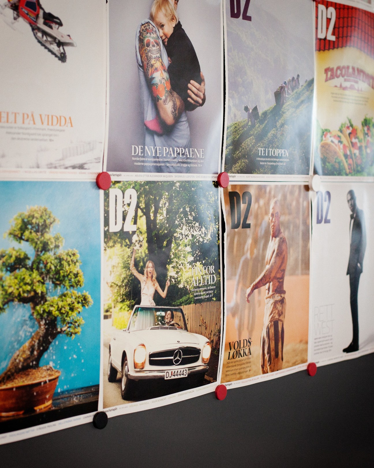 Magazine covers of Dagens Næringsliv's D2 culture supplement pinned to a wall.