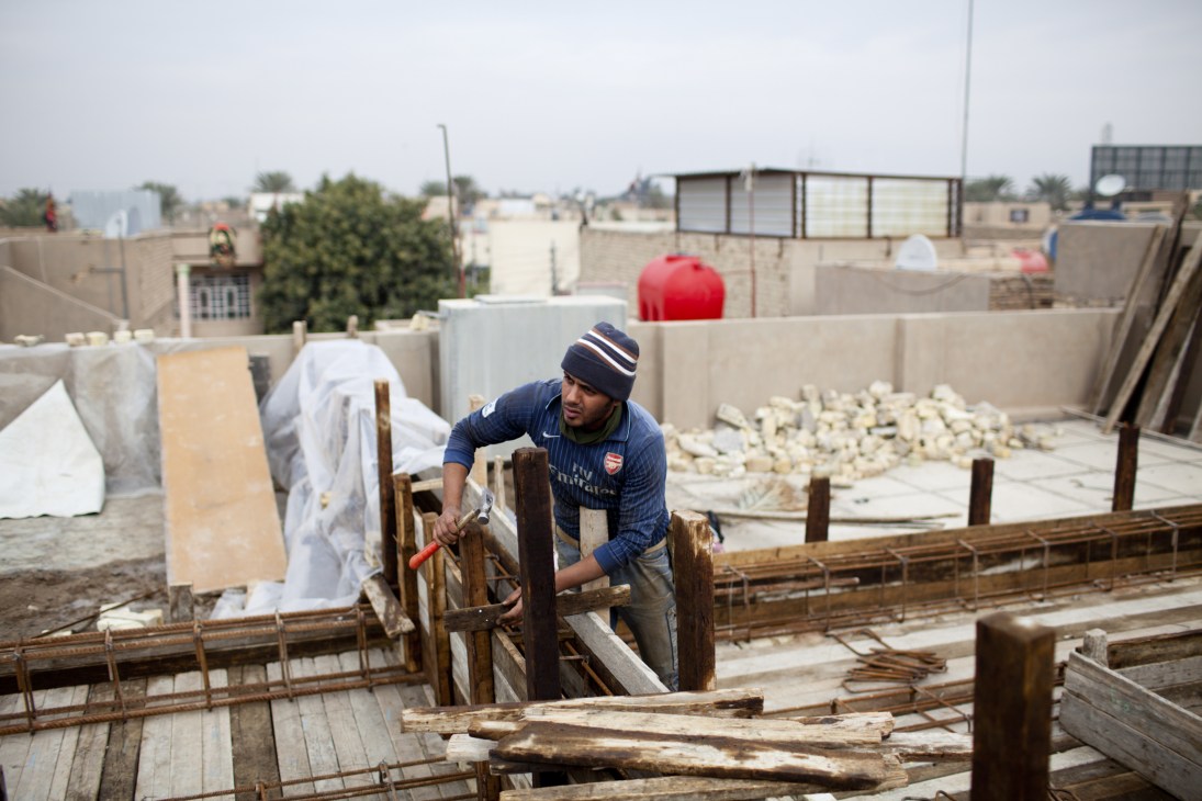 A construction worker builds wooden framework for new houses in Baghdad's Amil district.