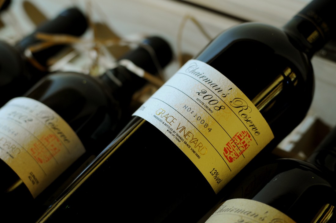 Grace Vineyard wine bottles with yellow and white labels displayed at an angle.