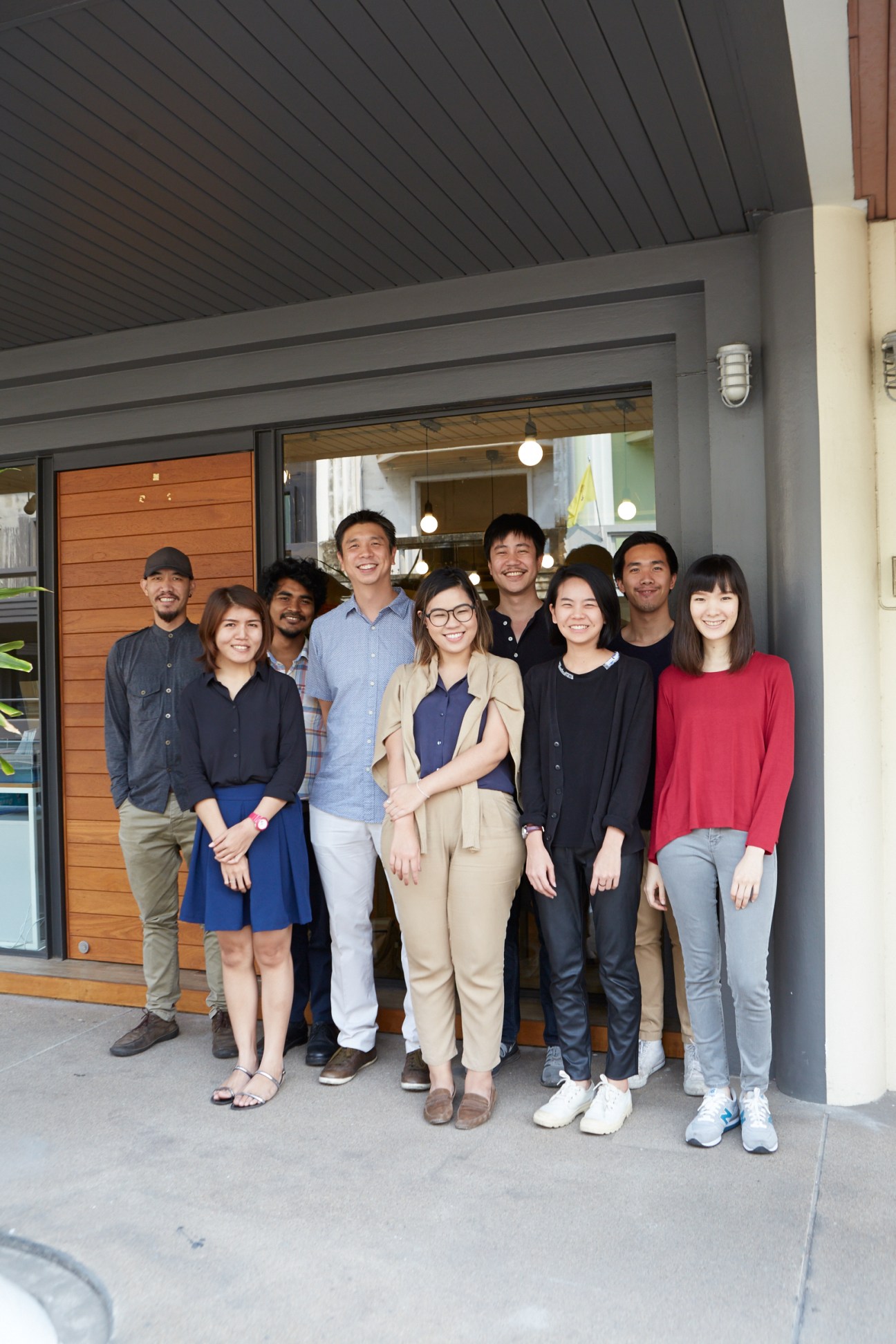 Chat Architects team of nine people standing in front of their Bangkok office, with Chatpong Chuenrudeemol fourth from left.