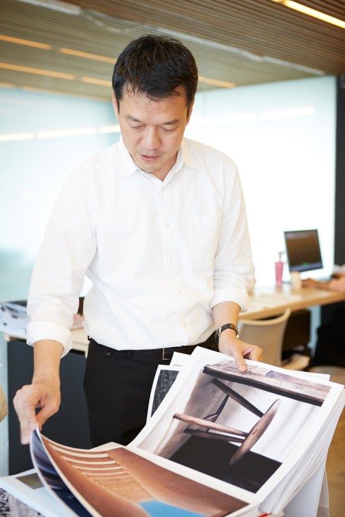 Boonlert Hemvijitraphan examines design materials and samples at his desk in the Boon Design office.