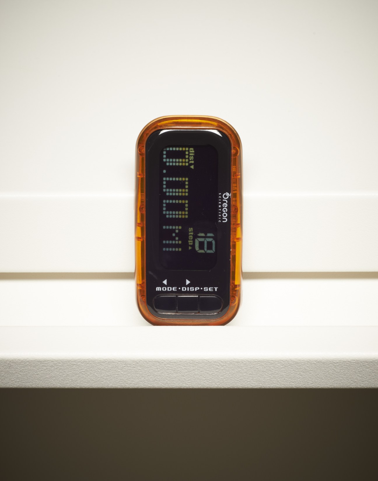 Oregon Scientific Marathon Pedometer with orange translucent casing and digital display showing step count.