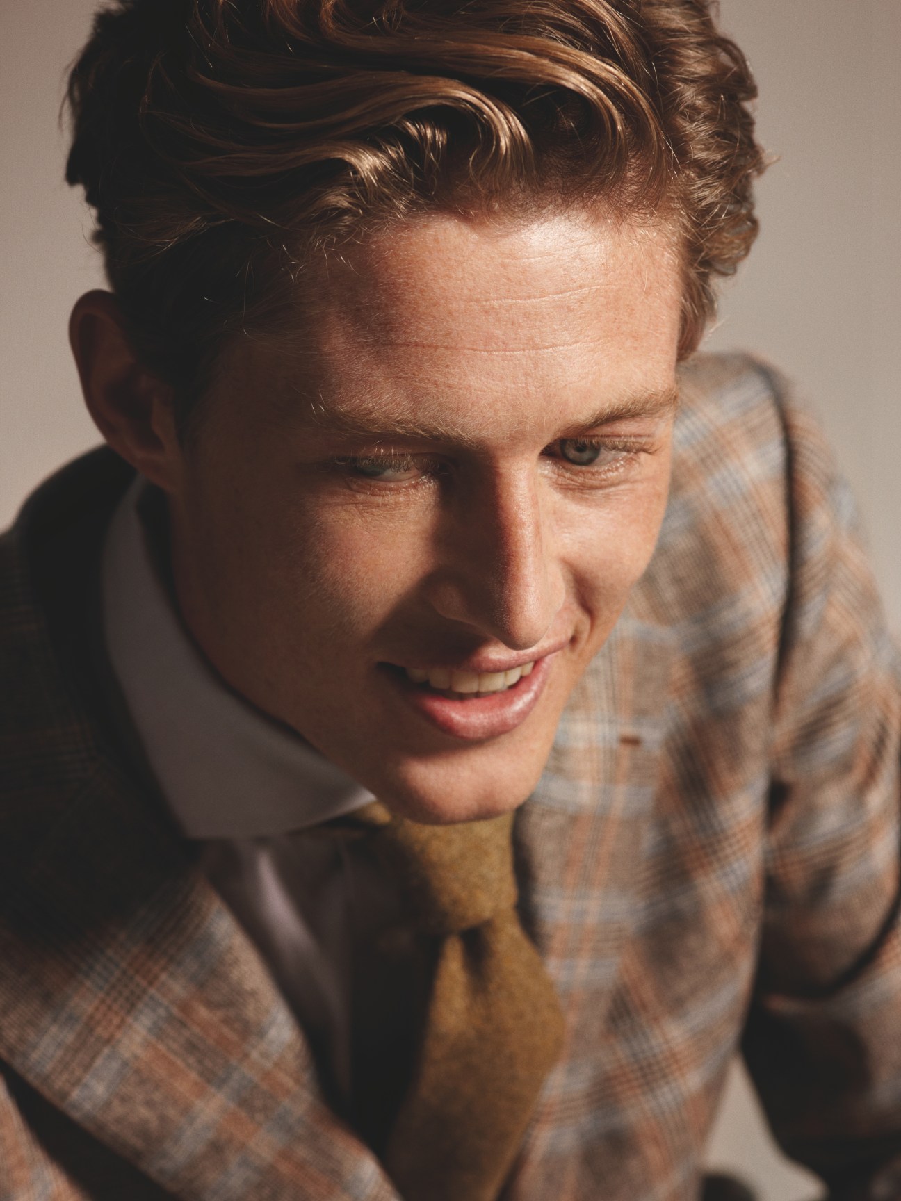 Man wearing a Sartorio jacket with Hackett shirt and tie, looking downward.