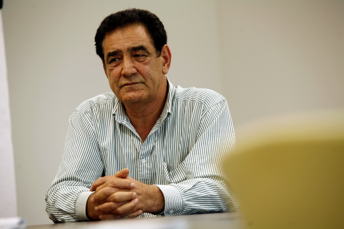 Hashem Mohmand, deputy director of Radio Free Afghanistan, sitting at a table wearing a striped shirt.