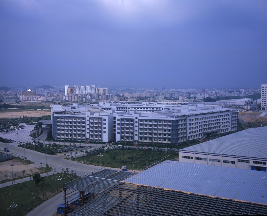 BYD headquarters campus in Shenzhen with modern blue-tinted buildings and solar panels in foreground.