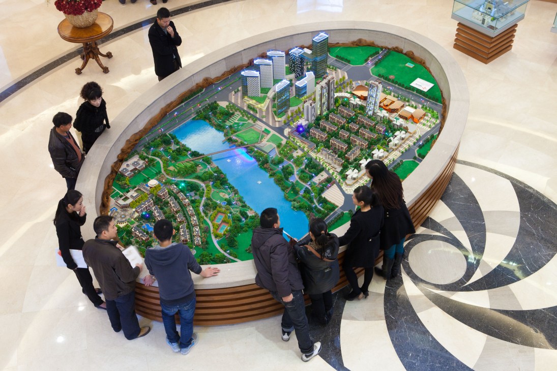Prospective home buyers viewing an architectural model of the Nordic City development in Chengdu.