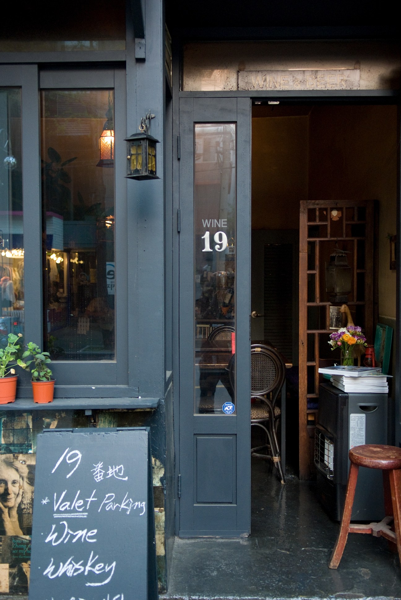 Bar 19 storefront on Garosu-gil with dark facade, illuminated signage and wooden door.