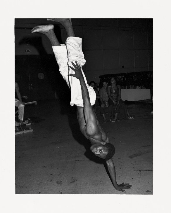 Brazilian capoeirista performing a handstand during opening ceremony entertainment.