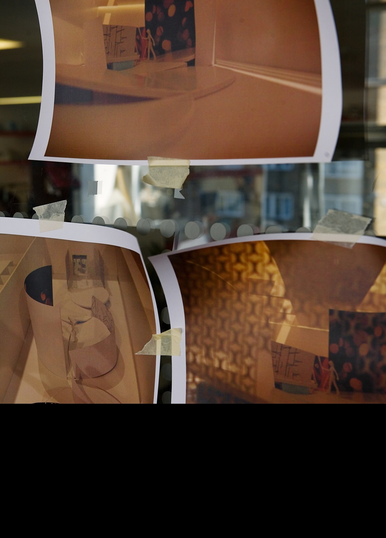 Printed architectural renderings and sketches taped to a glass surface at Arup's office.