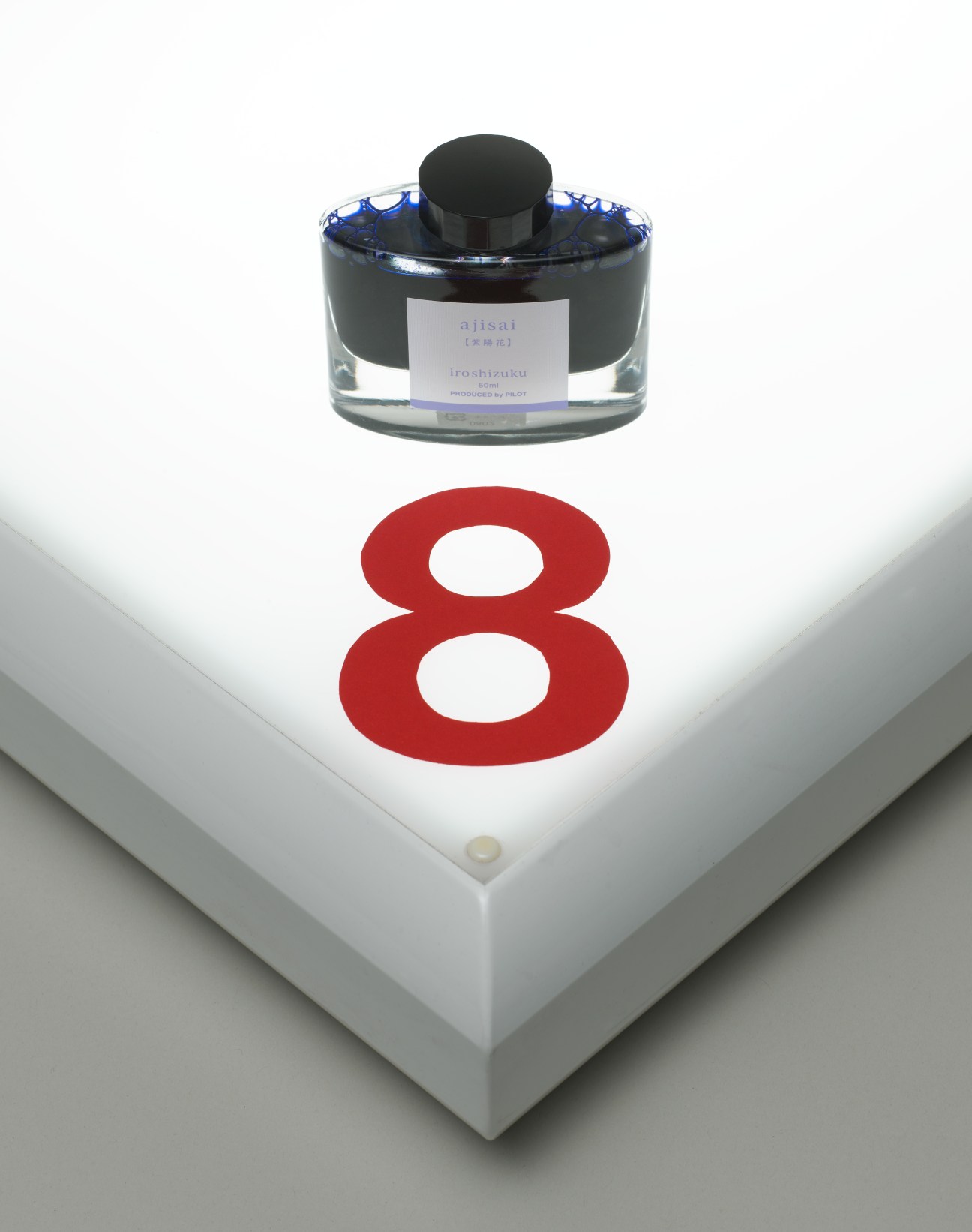 Pilot Iroshizuku bottled ink in ajisai hydrangea blue displayed above a red number 8 on white base.
