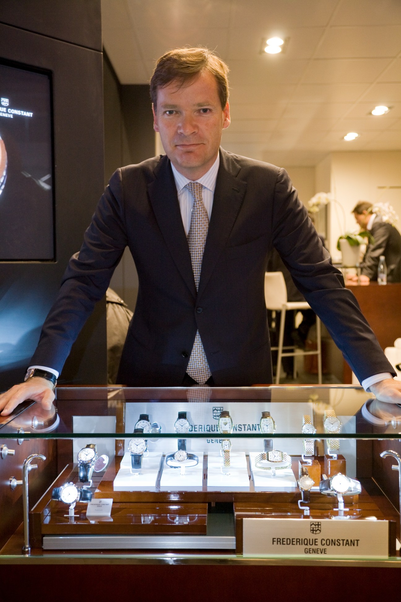 Dr Peter Stas, founder of Frédérique Constant, stands behind a display case of watches at Baselworld.