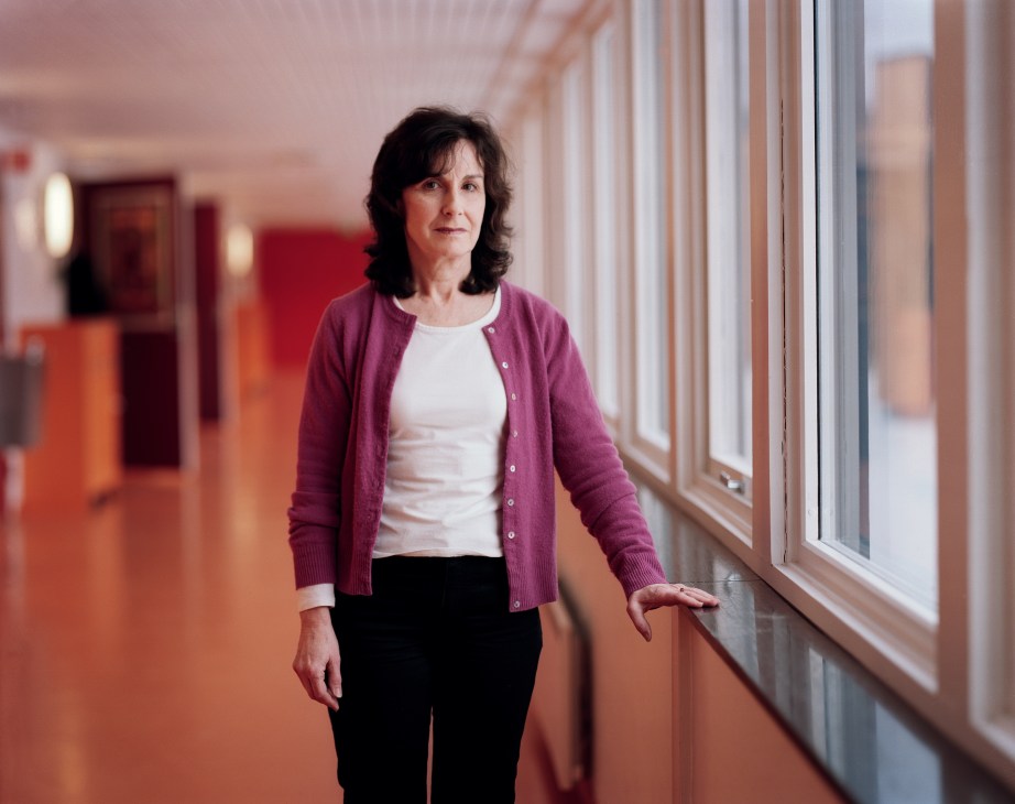 Rona McDonald, art, design and technology teacher, standing in a colorful school corridor with orange flooring and large windows.