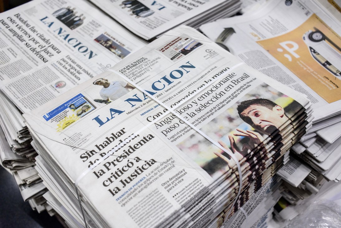 Stacked copies of La Nación newspaper bound with twine, ready for distribution.