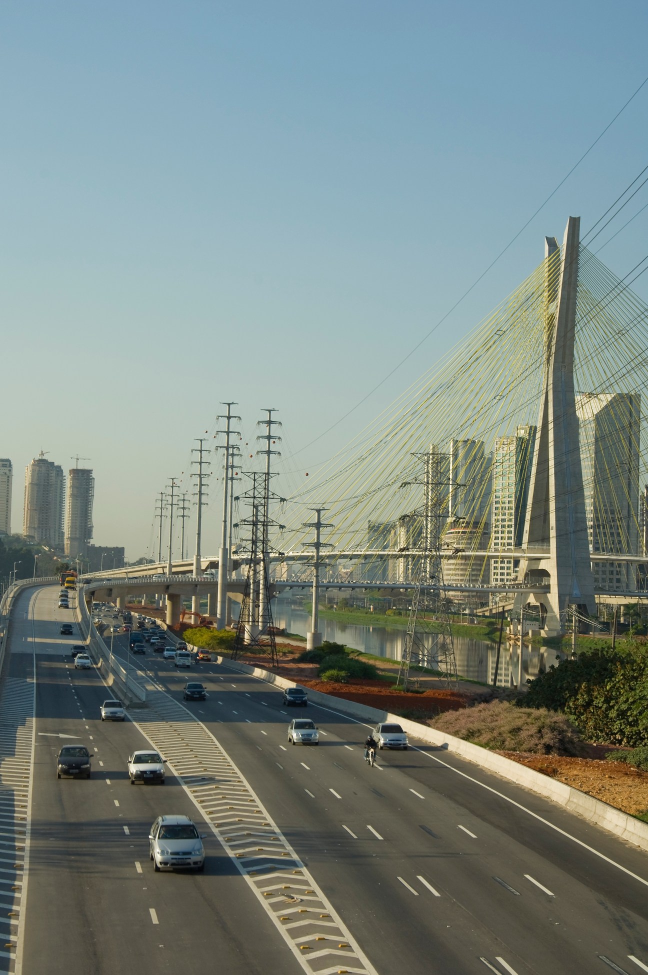 São Paulo highway with sparse traffic and cable-stayed bridge in background.