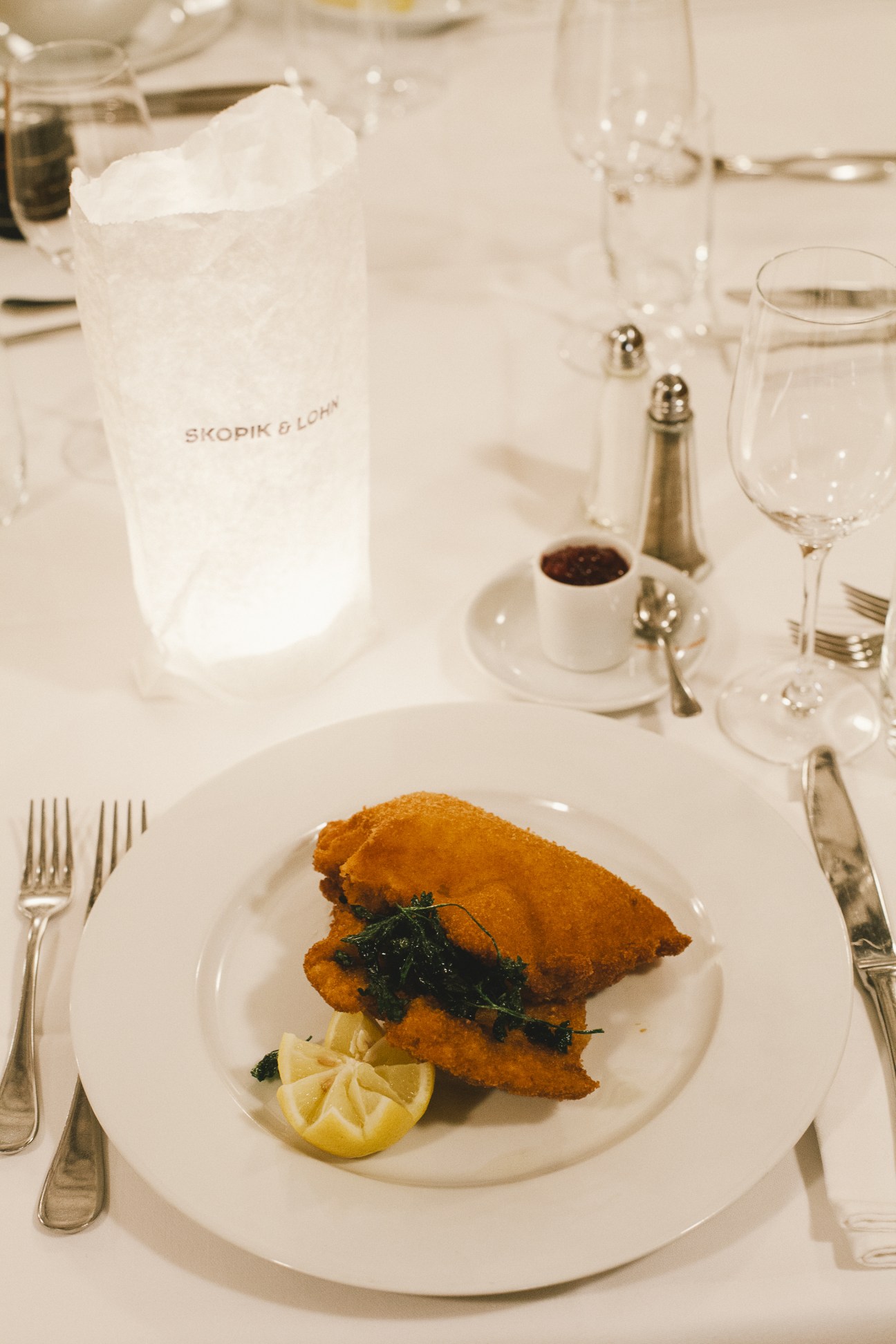 Plated Wiener Schnitzel with lemon and greens at Skopik & Lohn restaurant in Vienna.