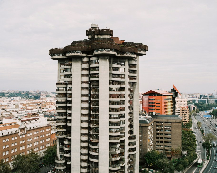 Torres Blancas apartment tower in Madrid with fanned-out top platforms and circular stacked balconies overlooking the city skyline.