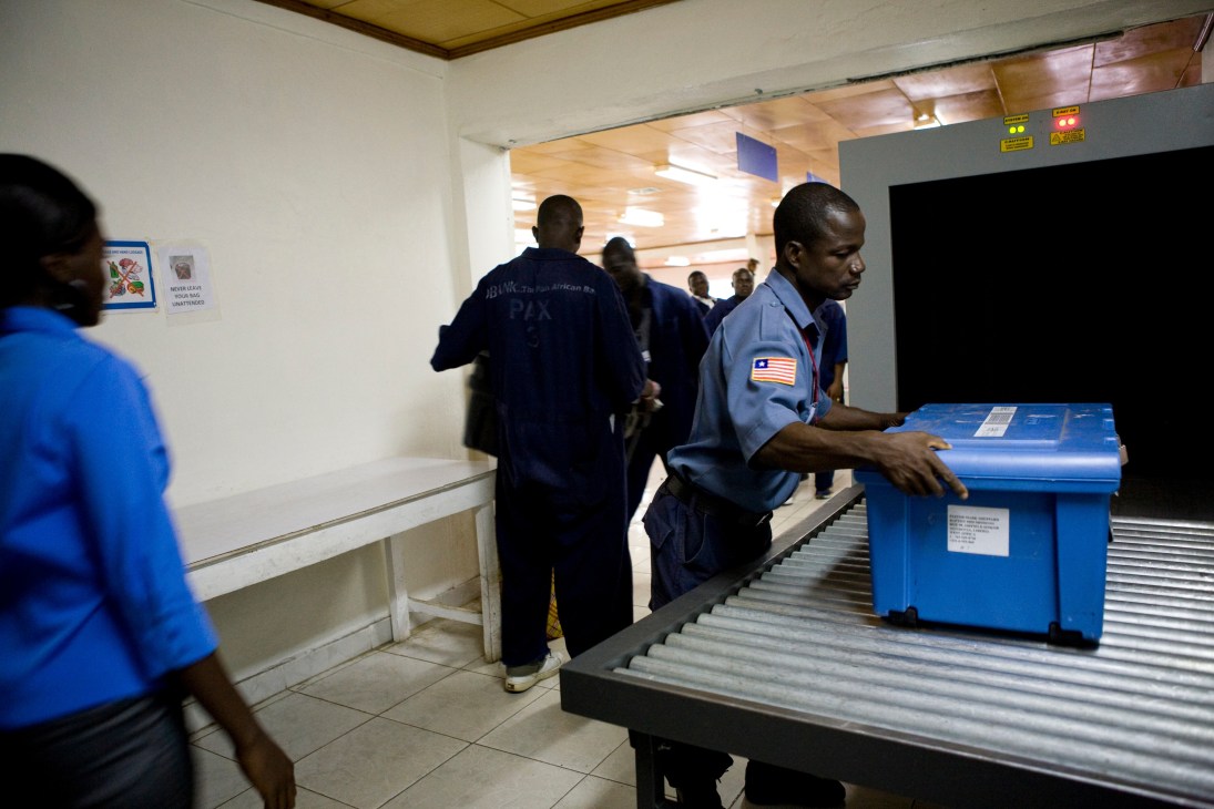 Airport security staff operating an X-ray machine at Roberts International Airport in Monrovia, Liberia.