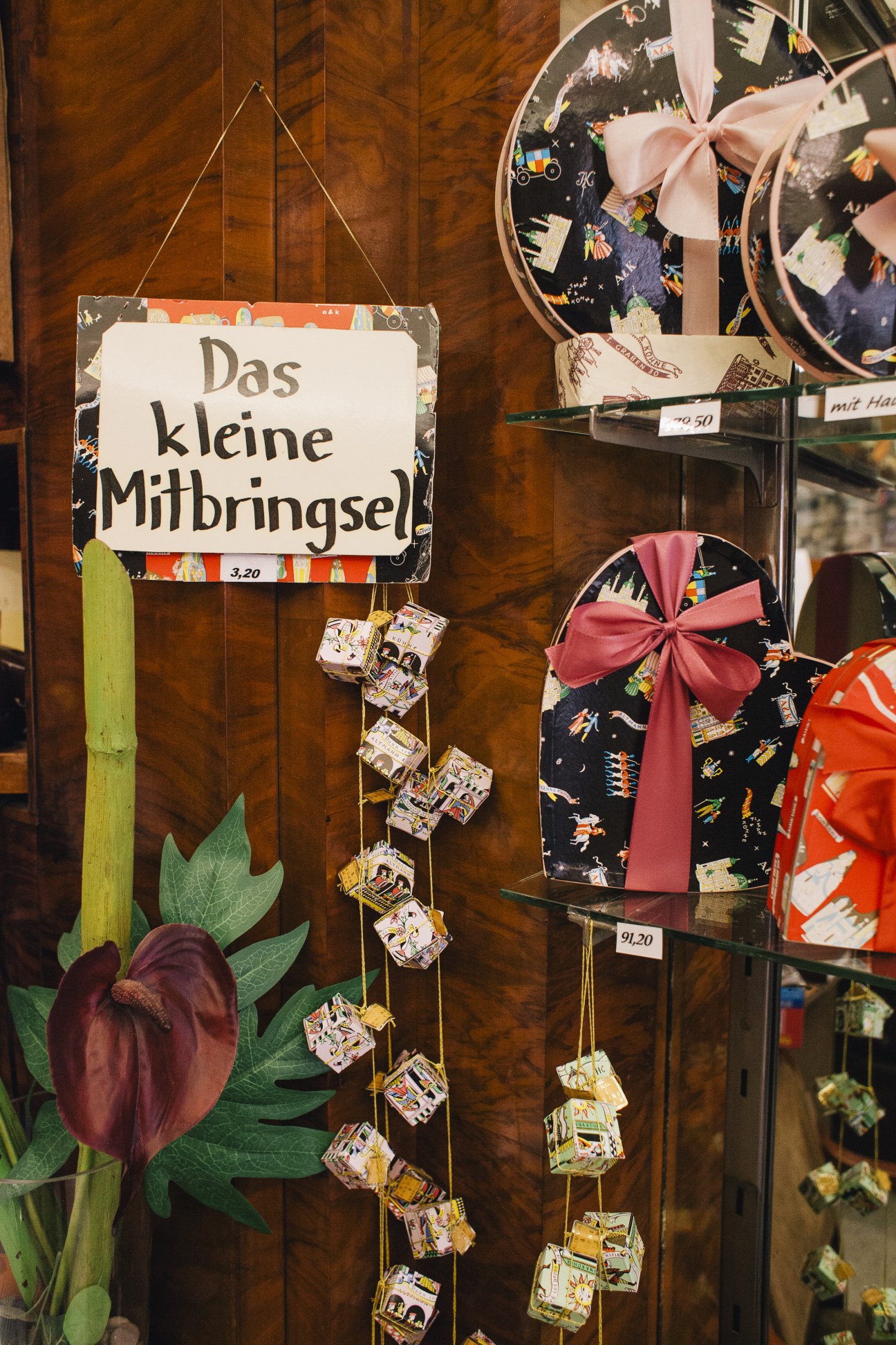 Window display at Altmann & Kühne confectionery showing hanging chocolate boxes and packaged sweets with decorative ribbons.