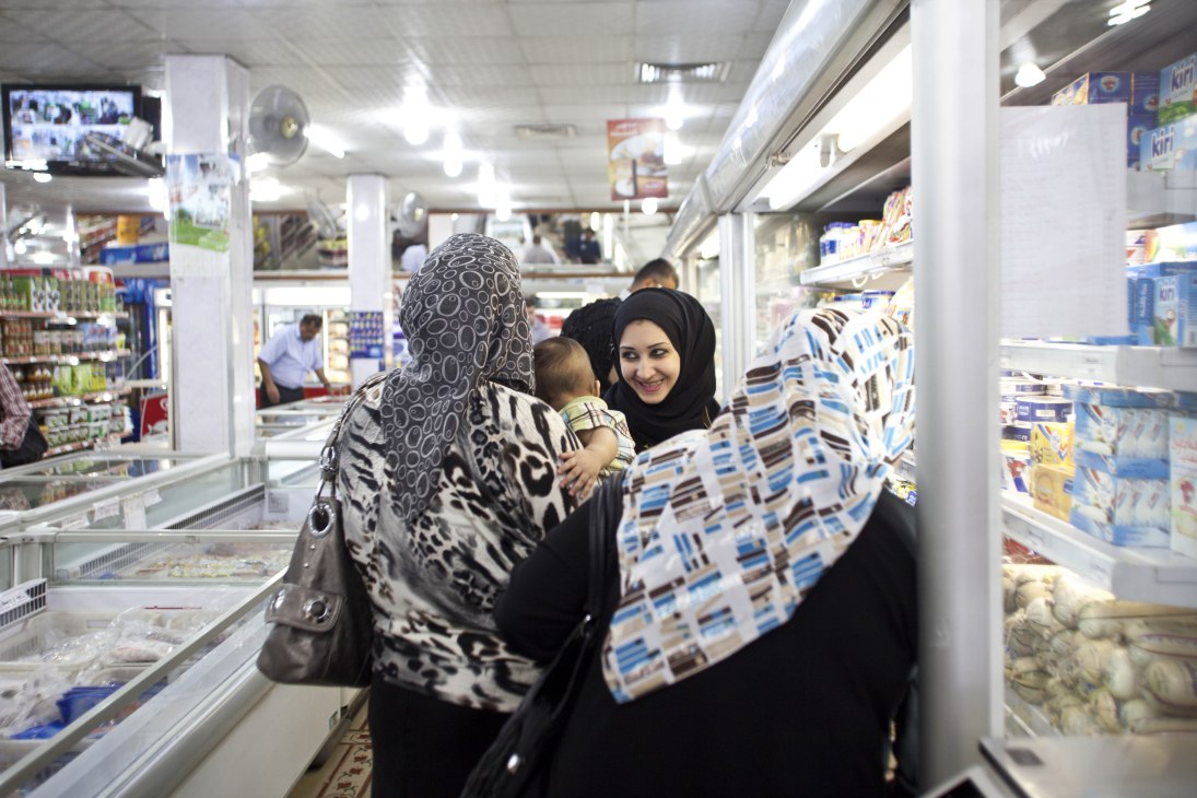 Women shopping in a grocery store in Basra during evening hours to escape daytime heat.