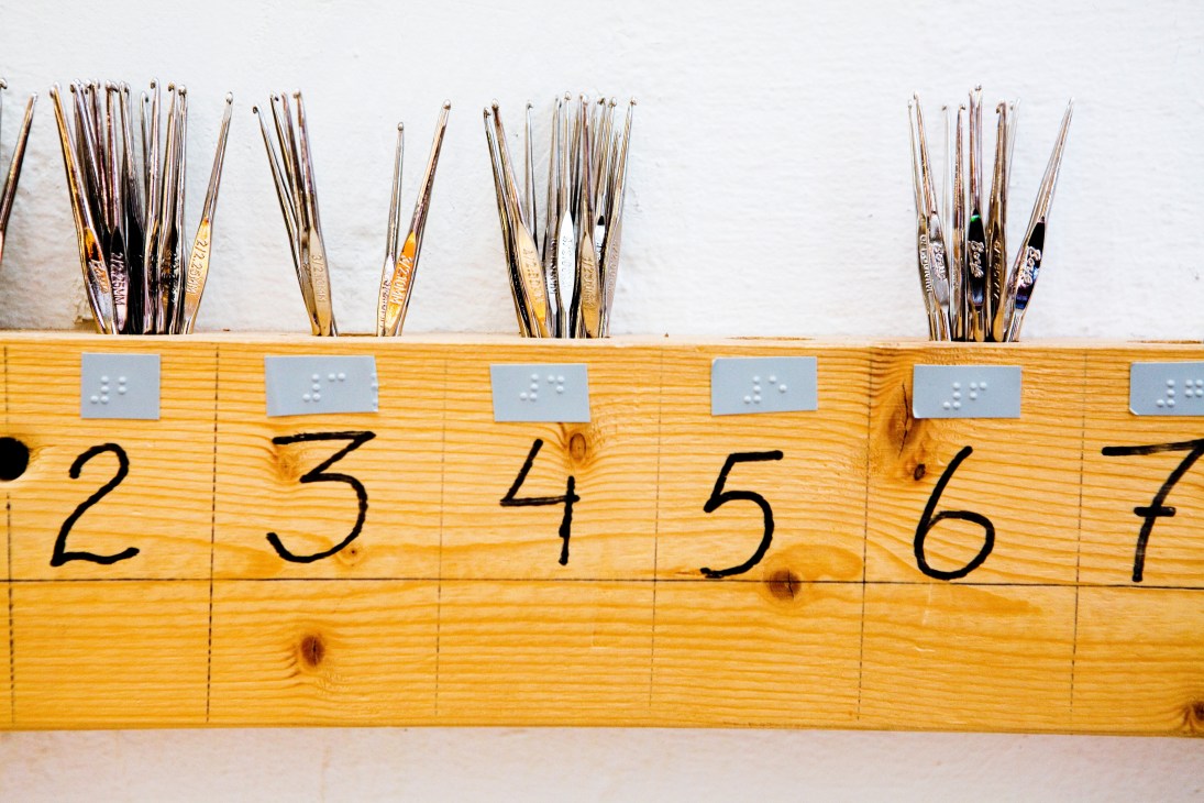 Binding needles stored in wooden boxes labeled with numbers and Braille dots for visually impaired workers at Iris Hantverk.