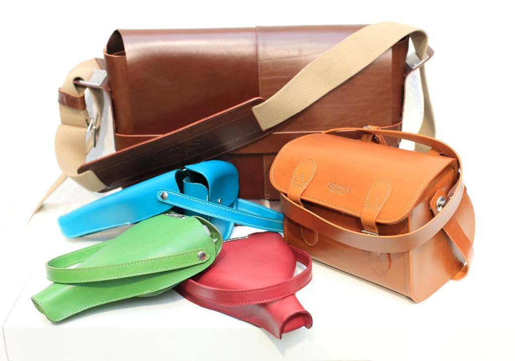 Brooks retro cycle accessories including leather bags and colorful saddle covers in brown, blue, green and red.